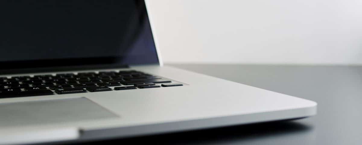 silver laptop computer on black table