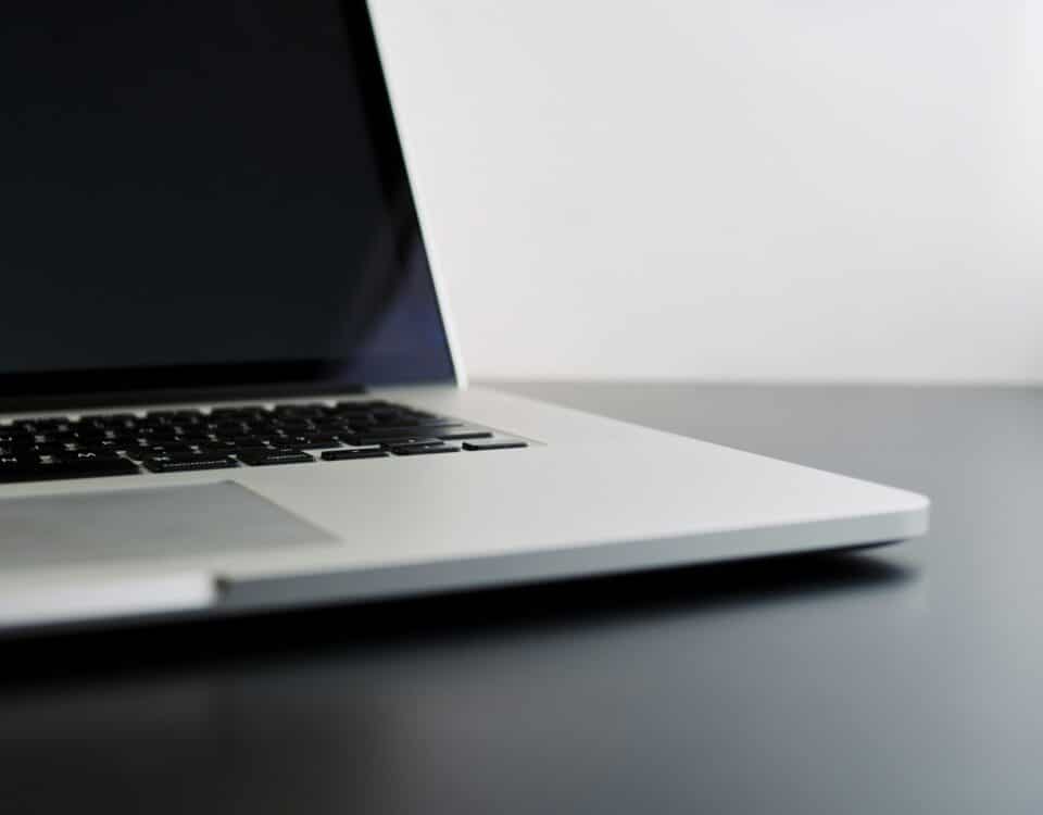 silver laptop computer on black table