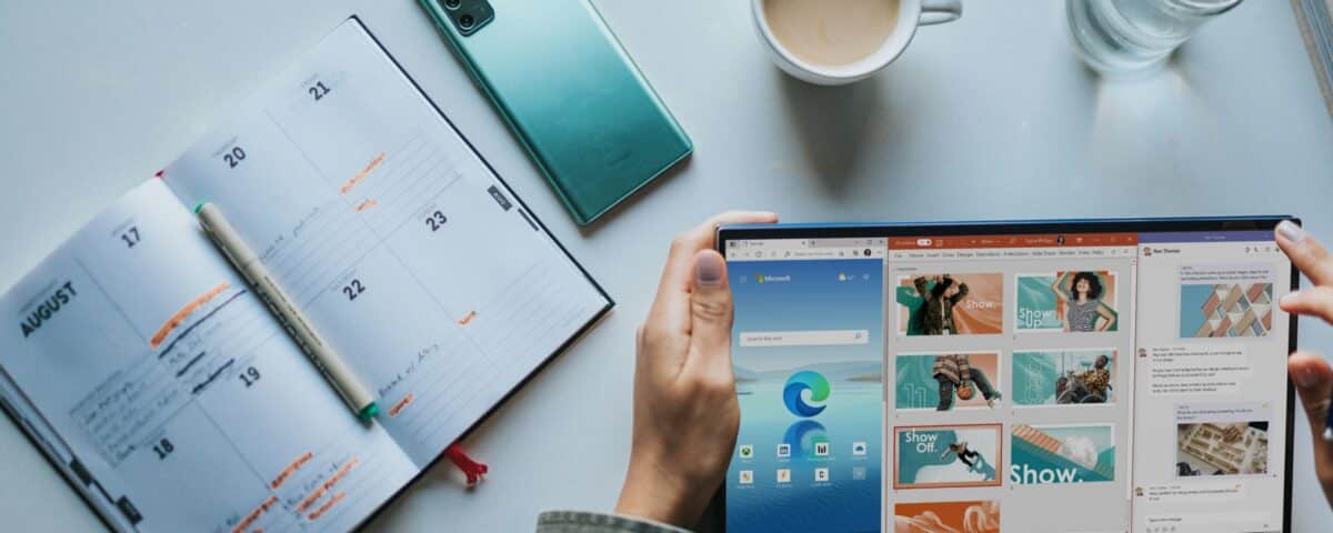 person using Windows 11 computer beside white ceramic mug on white table