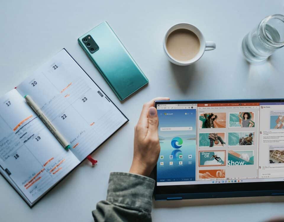 person using Windows 11 computer beside white ceramic mug on white table
