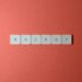 Free Close-up of keyboard keys spelling 'BACKUP' placed on a coral-colored surface. Stock Photo